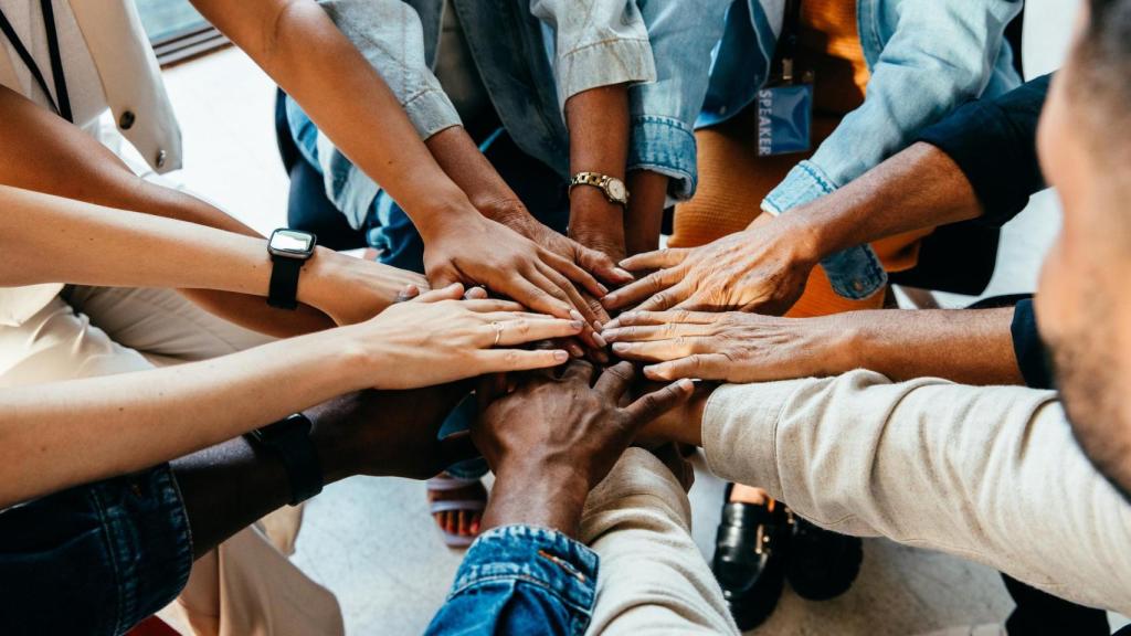 Un grupo de personas uniendo sus manos.