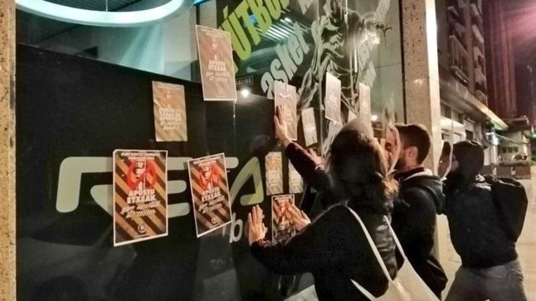 Jóvenes pegan carteles en el barrio de Tetuán (Madrid) contra las casas de apuestas.