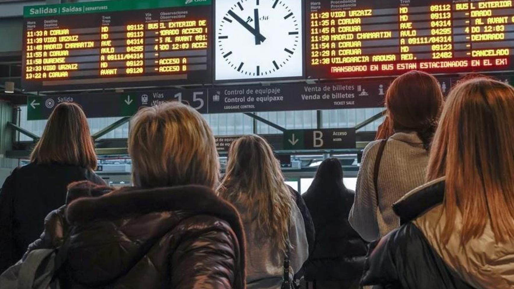 Viajeros siguen el panel informativo de la estación de tren de Santiago de Compostela este lunes.