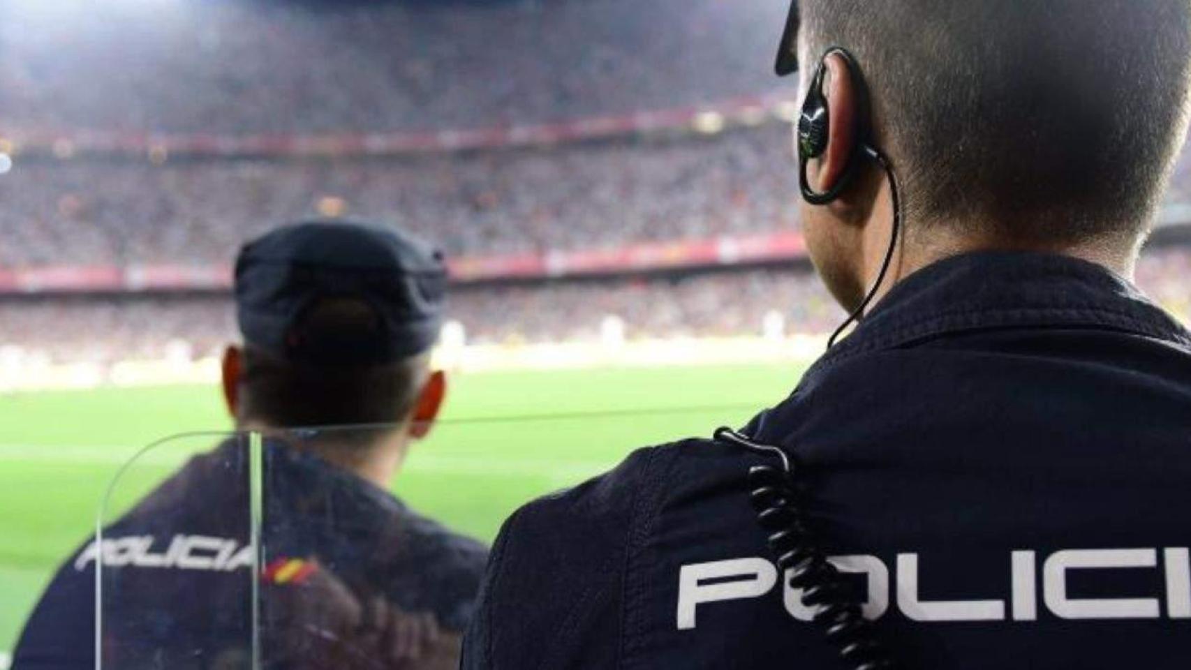 Dos agentes de la Policía Nacional velan por la seguridad durante un partido de fútbol.