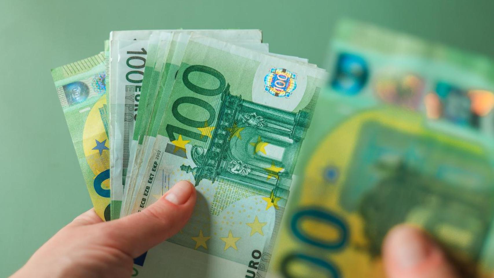 Una persona con billetes de 100 euros.