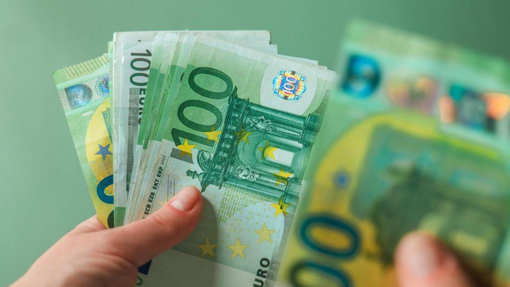 Una persona con billetes de 100 euros.