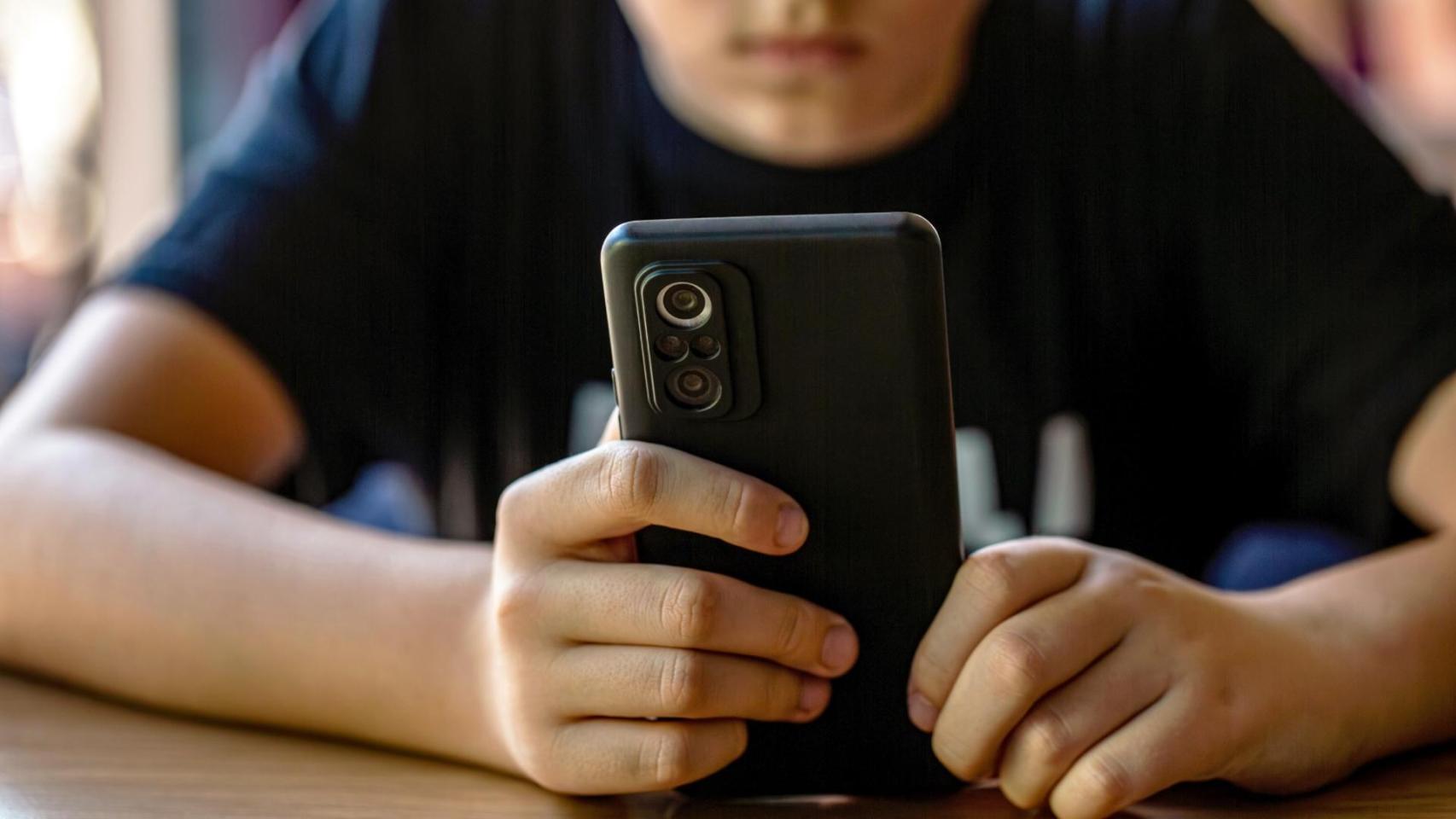 Un menor con un teléfono móvil