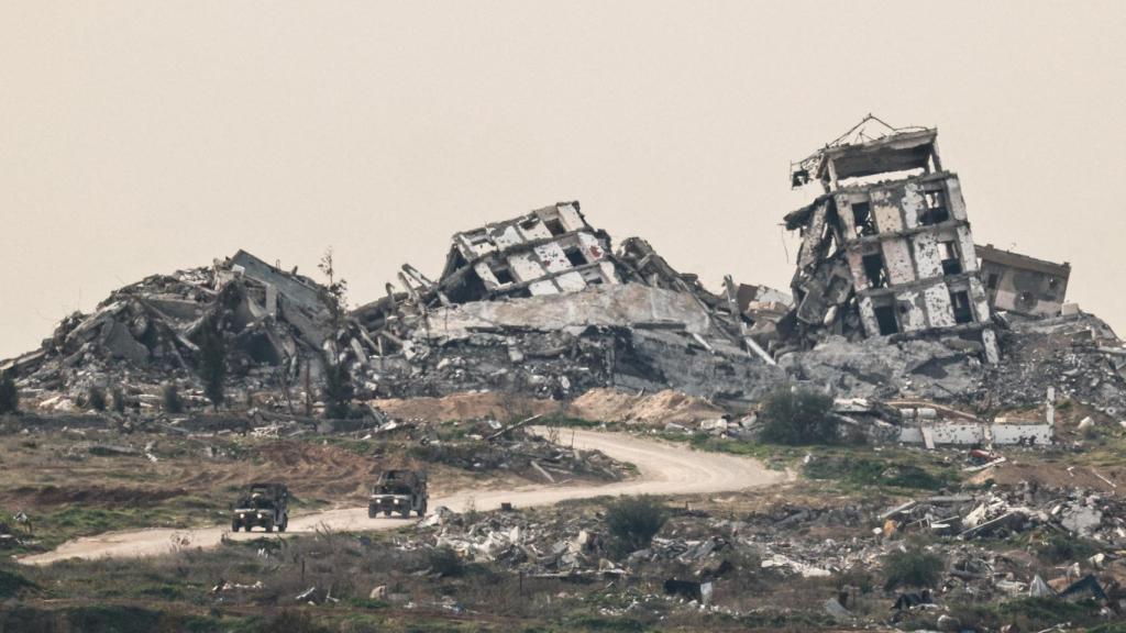 Vehículos militares israelíes pasan junto a la destrucción en Gaza, como se ve desde el lado israelí de la frontera entre Israel y Gaza en el sur de Israel, el pasado 21 de enero.