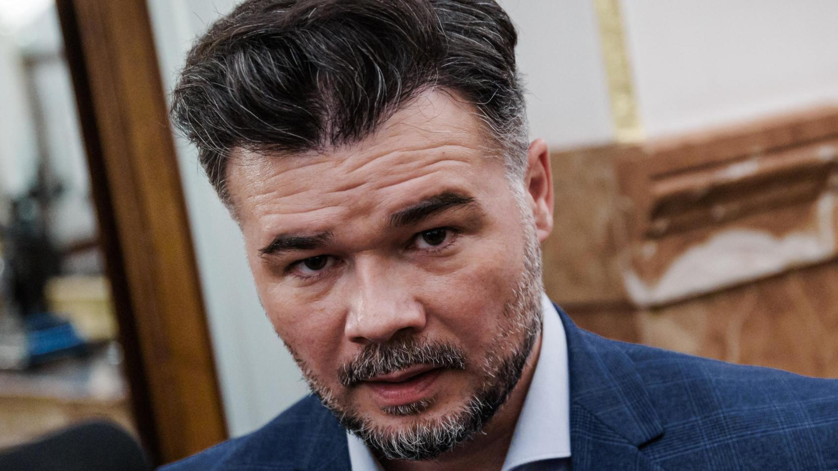 El rostro de Gabriel Rufián, captado en un pasillo del Congreso de los Diputados, condensa la tensión de la política hecha a pie de micrófono: cejas en guardia, mirada fija, silencio previo a la réplica.