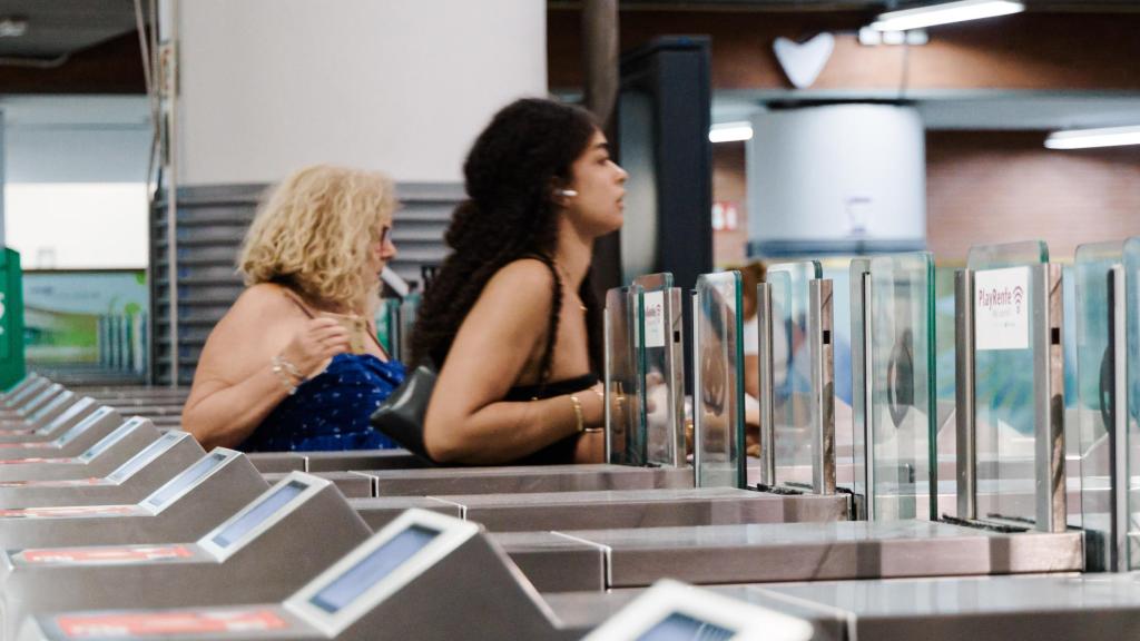 Usuarias cruzando los tornos del servicio de Cercanías de Madrid.