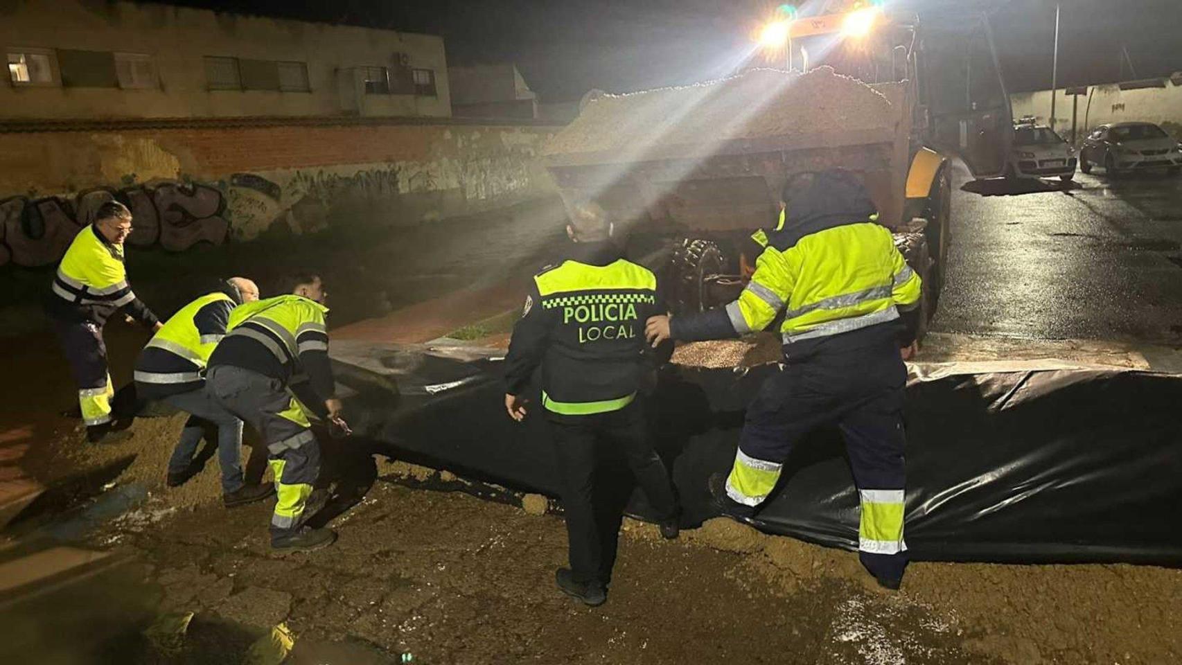Operarios municipales trabajando en la construcción de diques durante la noche del martes al miércoles.