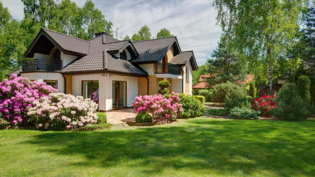 Una casa rodeada por un jardín con árboles y plantas.