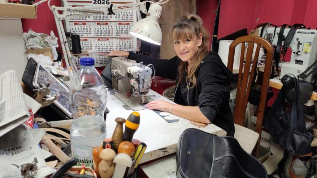 Azucena Torreiro entre máquinas de reparación y bolsos en el taller de Curtidos Orzán.