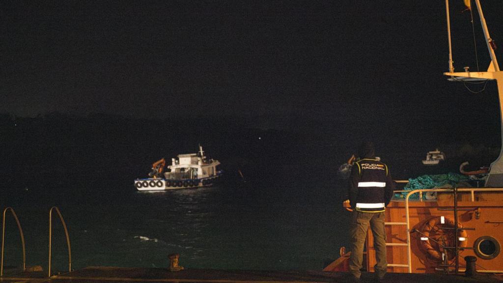 Agentes de la Policía Nacional y del servicio de aduanas colocan un muro de contención tras el hundimiento en O Grove