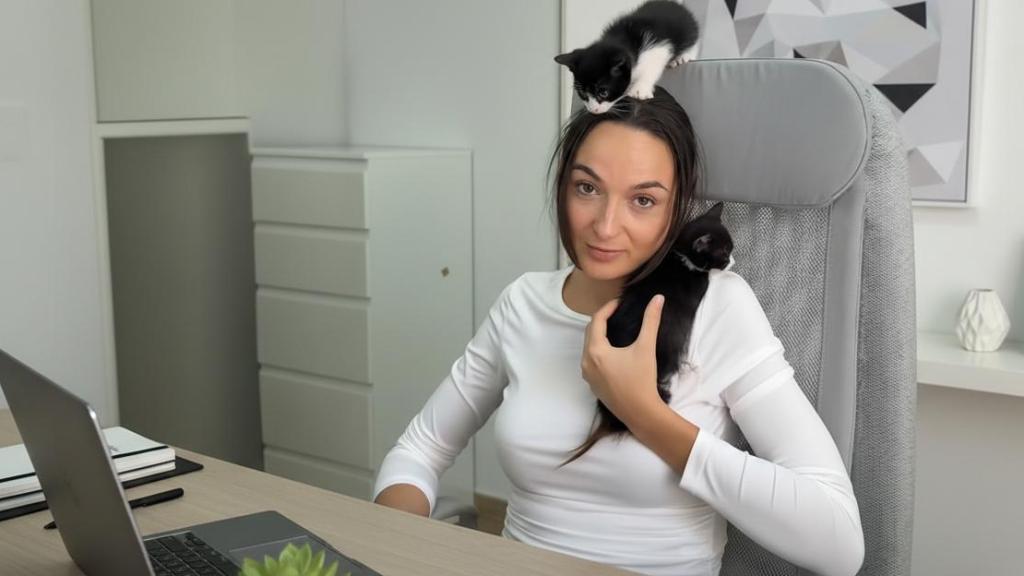 Claudia Cañellas con dos gatos en su oficina.