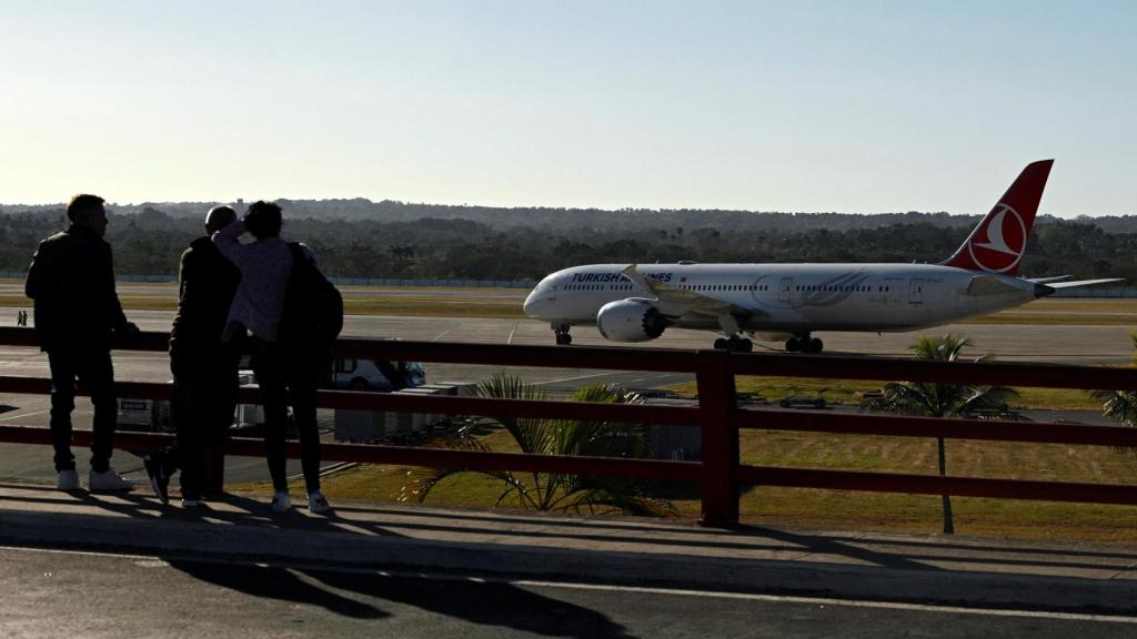 La gente observa un avión de Turkish Airlines varado en el Aeropuerto Internacional José Martí en La Habana.