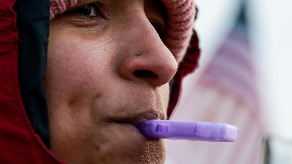 Una mujer soplando un silbato para alertar del ICE en Minneapolis.