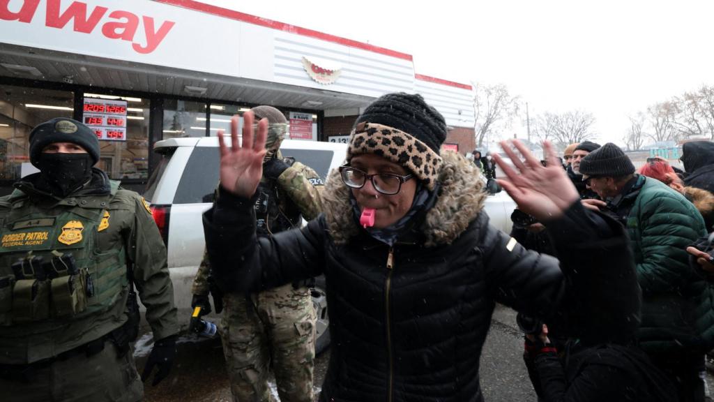 Una mujer soplando un silbato en una redada en Minneapolis.