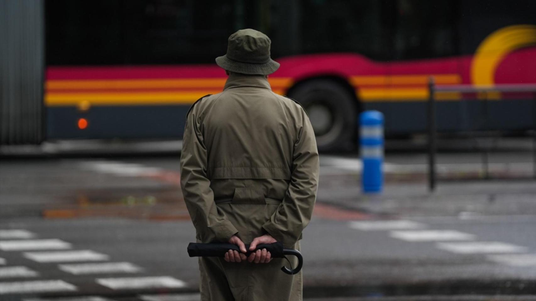 Un viandante por Sevilla se protege de los efectos climatológicos adversos de la borrasca Leonardo.