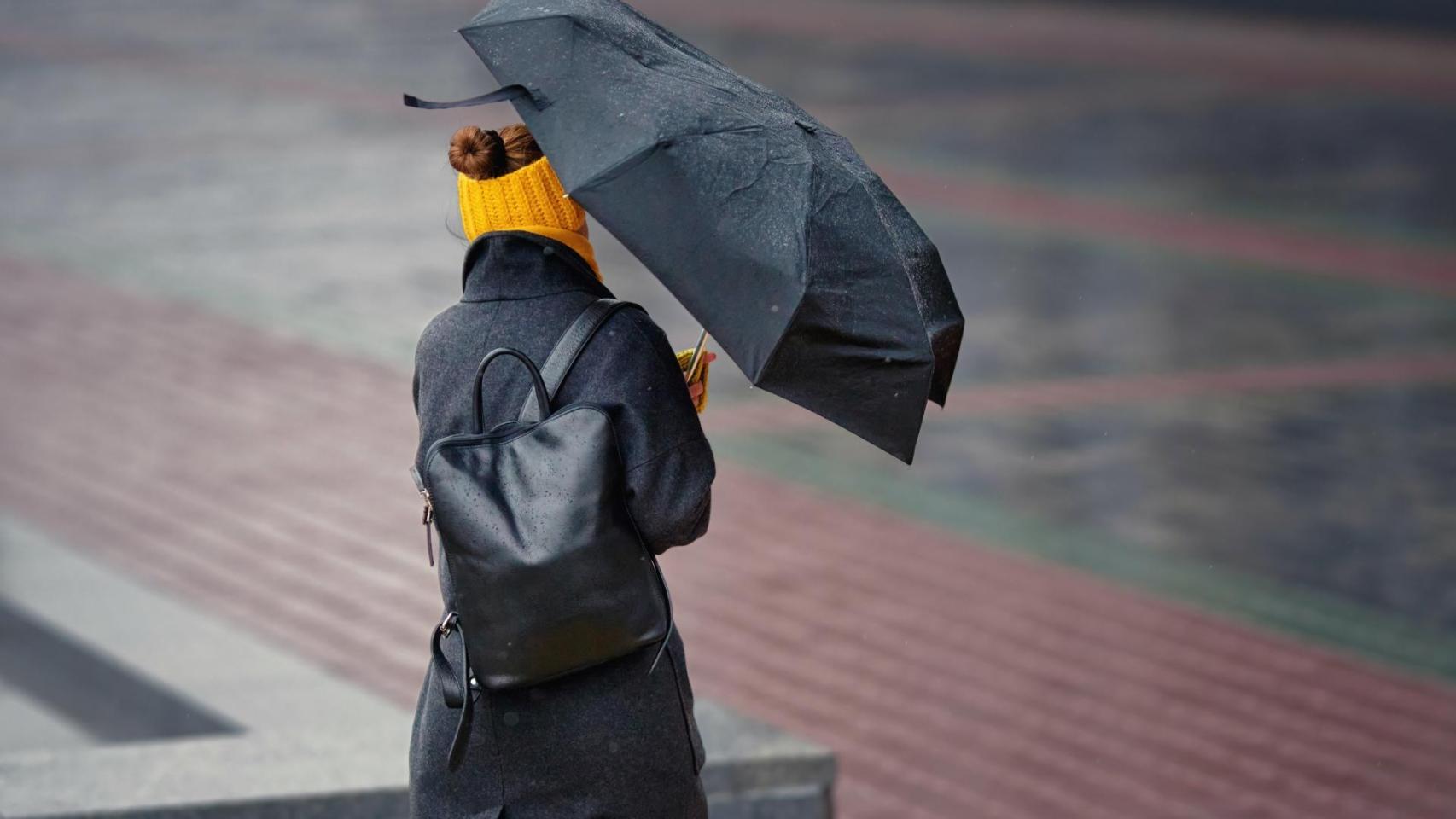 Una mujer lucha contra el fuerte viento