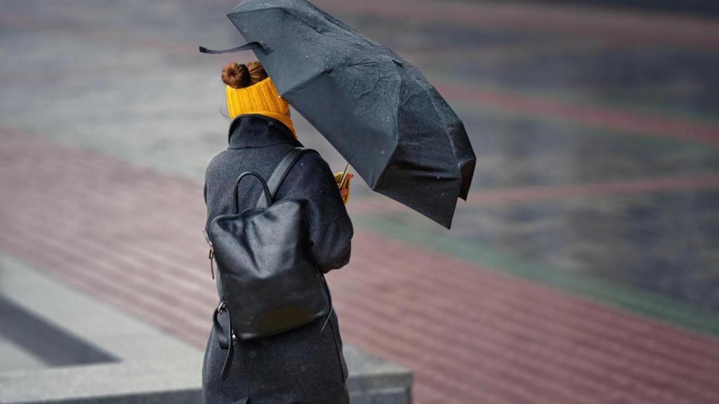 Una mujer lucha contra el fuerte viento