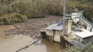 Maleza y troncos acumulados junto a la presa de Montearenas en el río Boeza en Ponferrada debido al temporal de lluvias