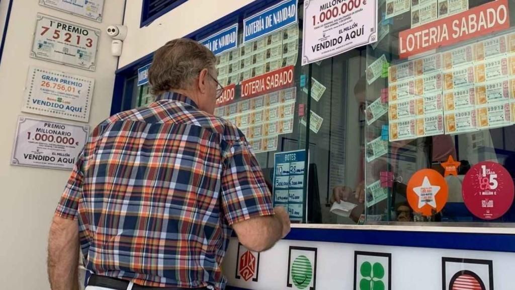Una persona comprando un boleto en una administración de loterías.