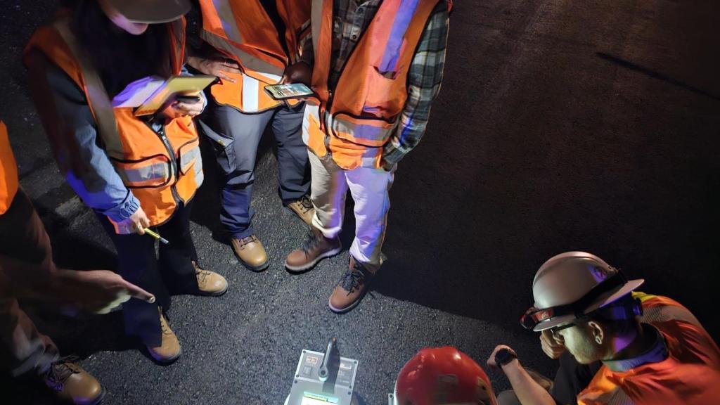 Operarios comprobando la carretera hecha con el asfalto fabricado con plástico.