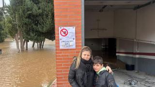 Verónica, vecina afectada por las inundaciones en Tudela de Duero, junto a su hijo en el garaje de su bloque y el río al lado.