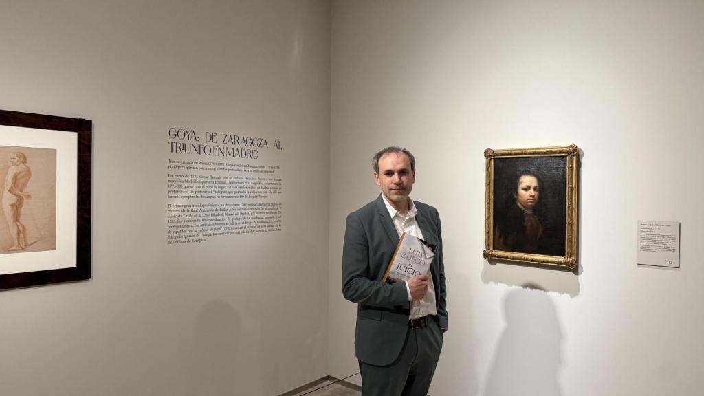Luis Zueco con su libro en la exposición 'Goya. Interludio'.