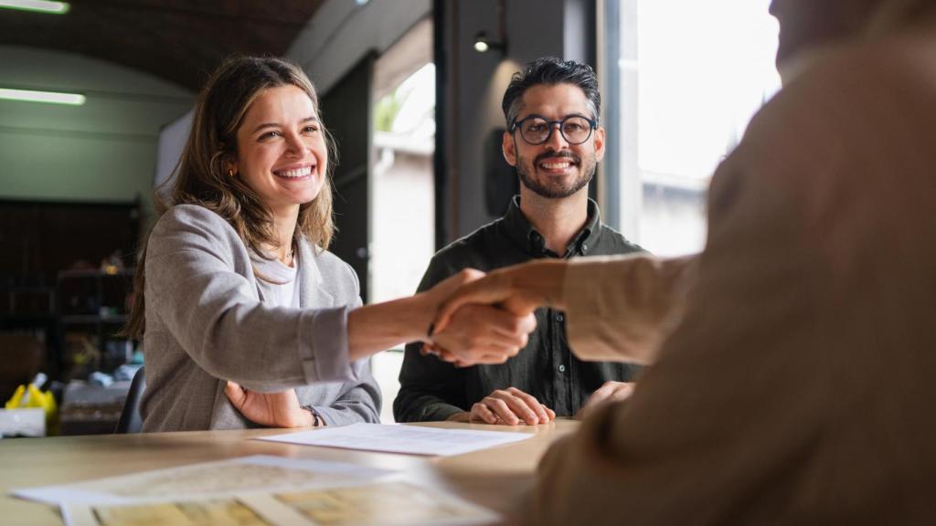 Socios comerciales que se dan la mano en una oficina.