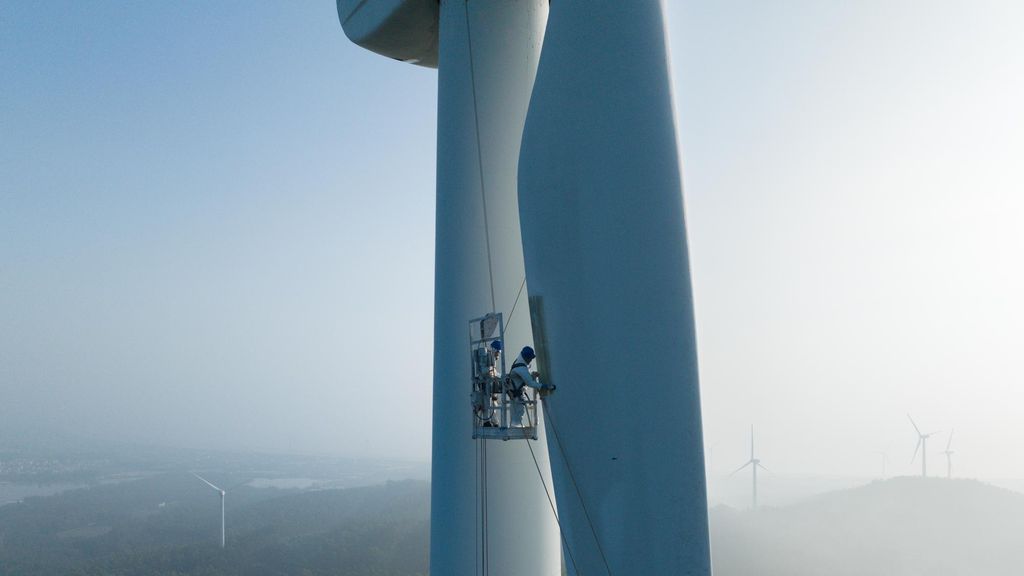 Trabajador eléctrico reparando instalaciones de turbinas eólicas.