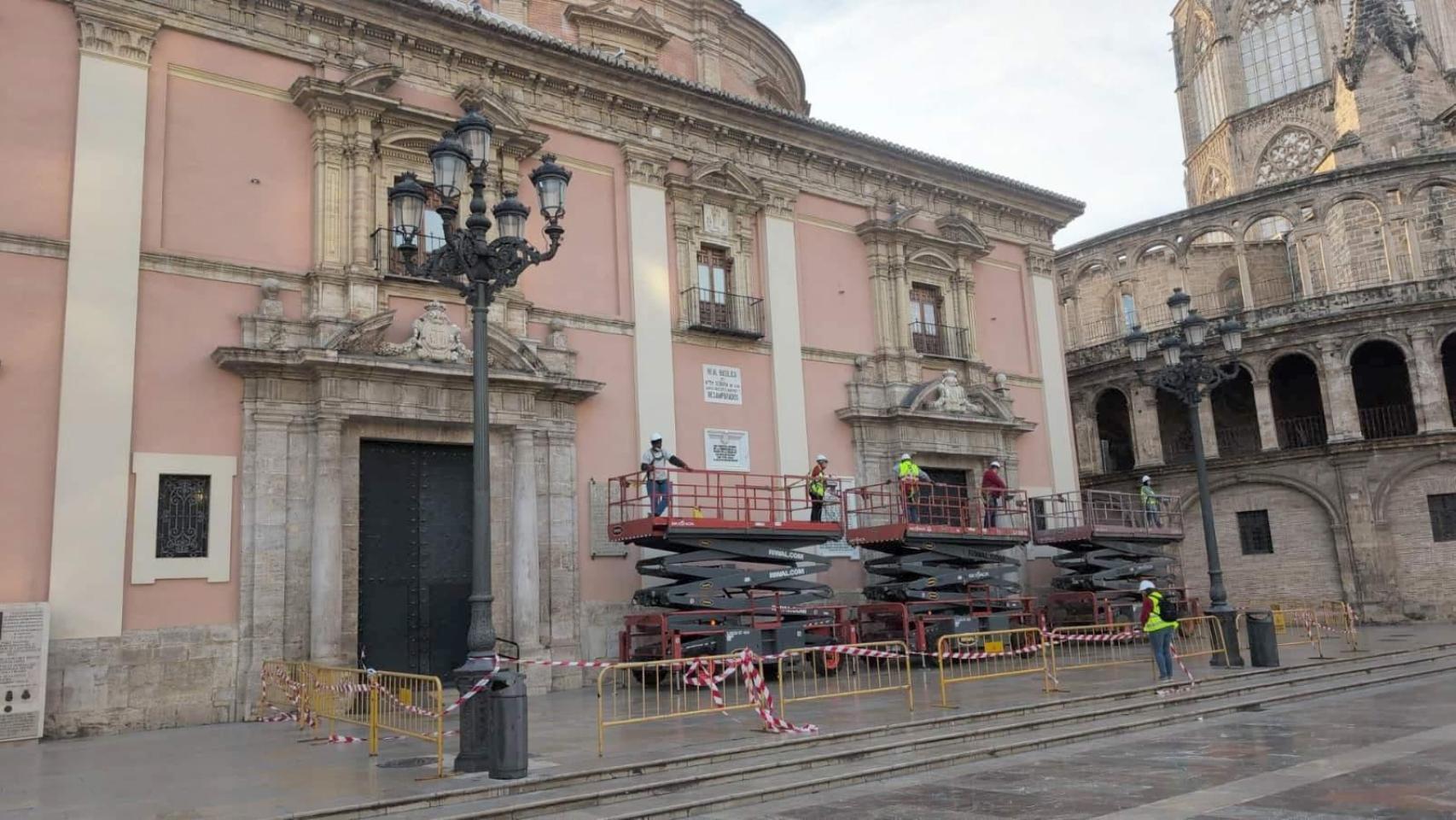 Los técnicos comienzan la retirada del toldo de la plaza de la Virgen de Valencia.