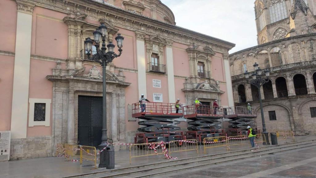 Los técnicos comienzan la retirada del toldo de la plaza de la Virgen de Valencia.