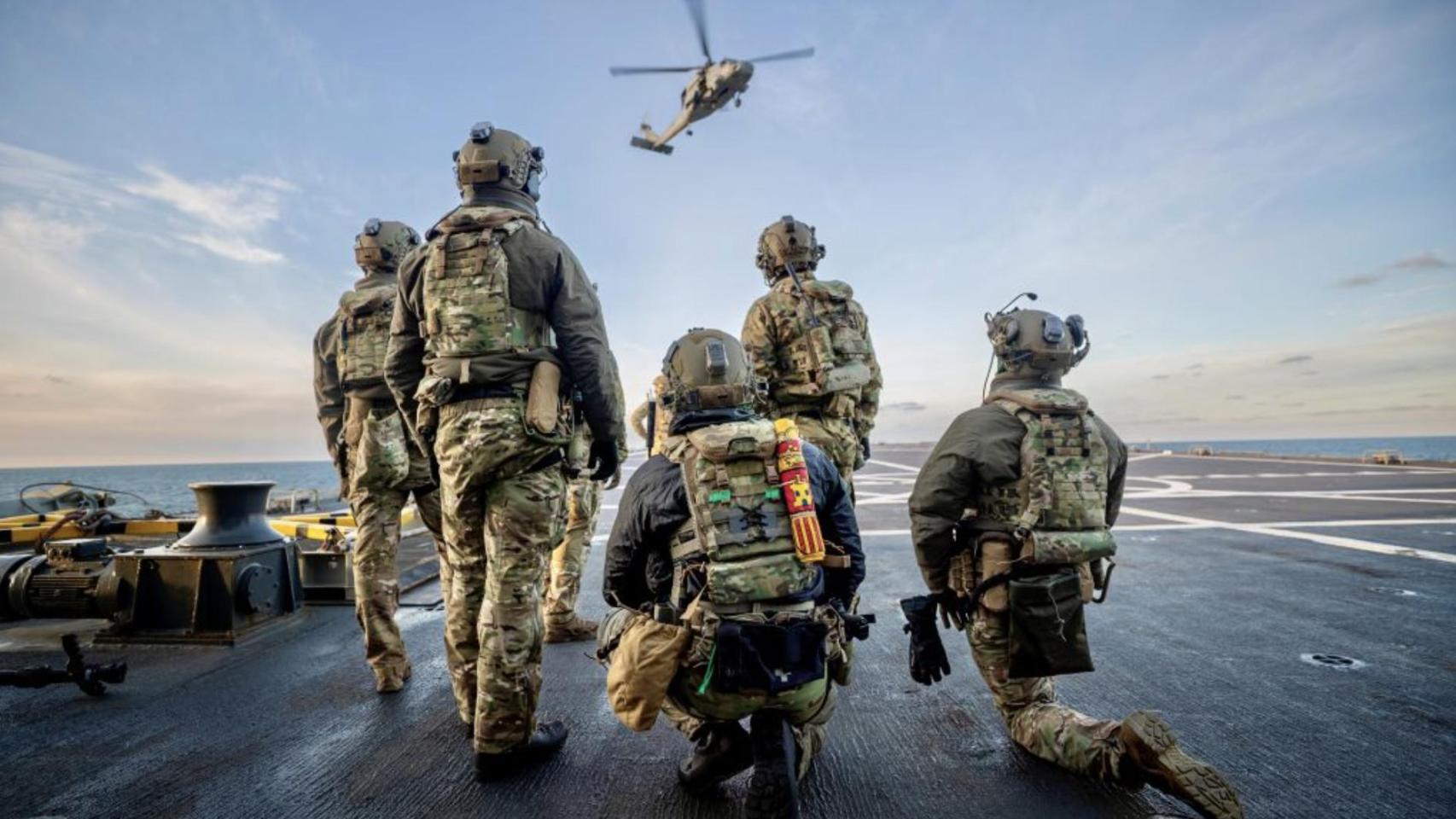 Personal español de operaciones especiales esperando la extracción en cubierta de barco.