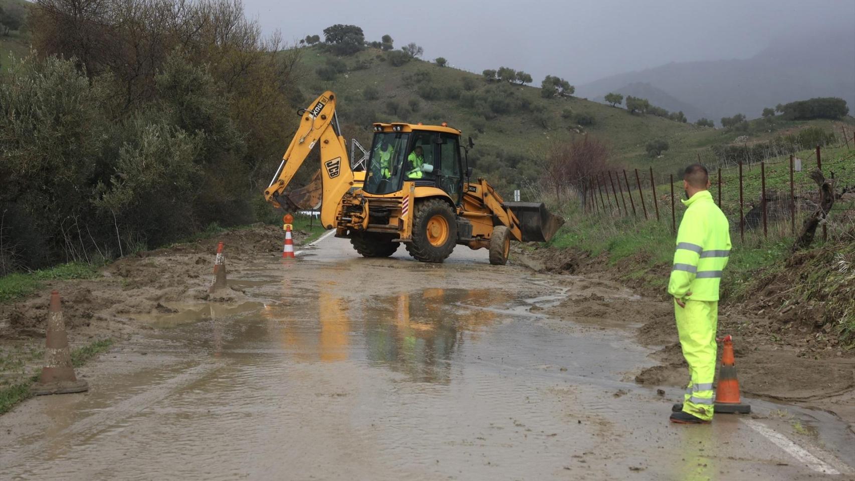 Operarios trabajan en una carretera anegada por las lluvias en Cádiz.