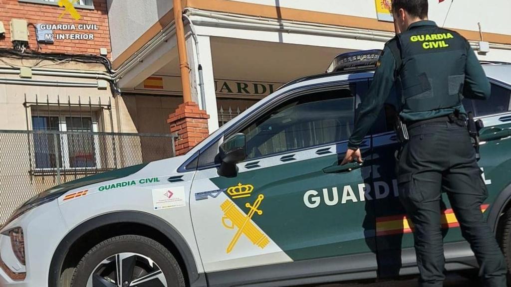 Un agente de la Guardia Civil junto a su vehículo.
