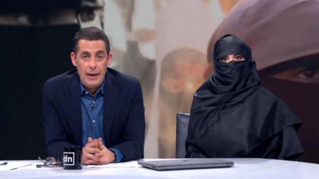 Naranjo junto a una periodista con el niqab.