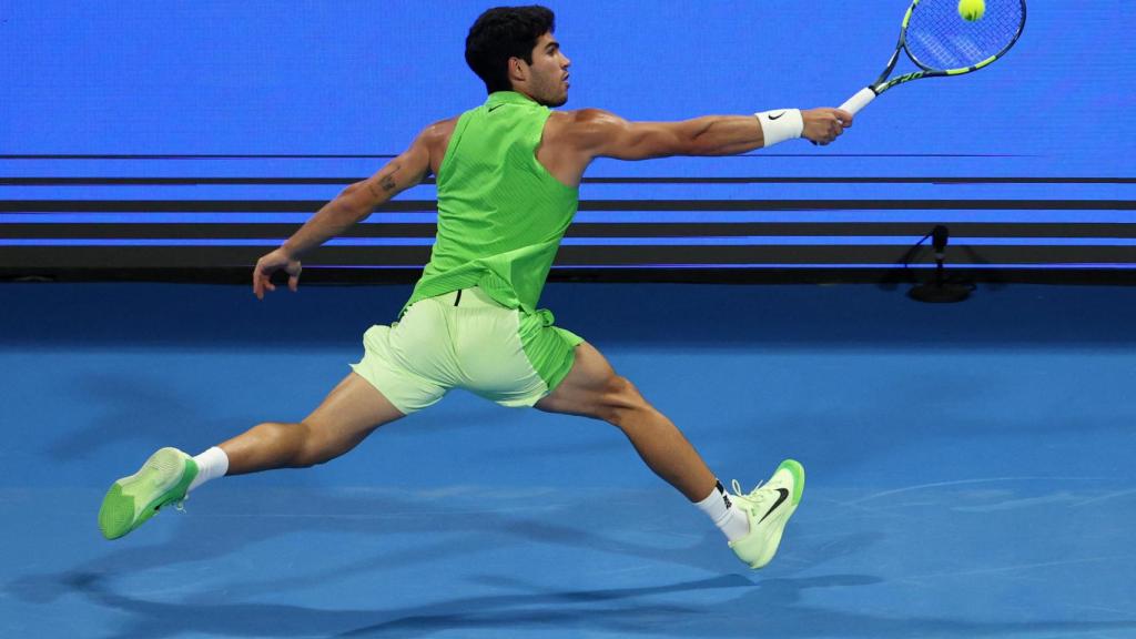 Alcaraz golpea la pelota de espaldas.