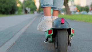Imagen de archivo de un usuario con un patinete eléctrico.