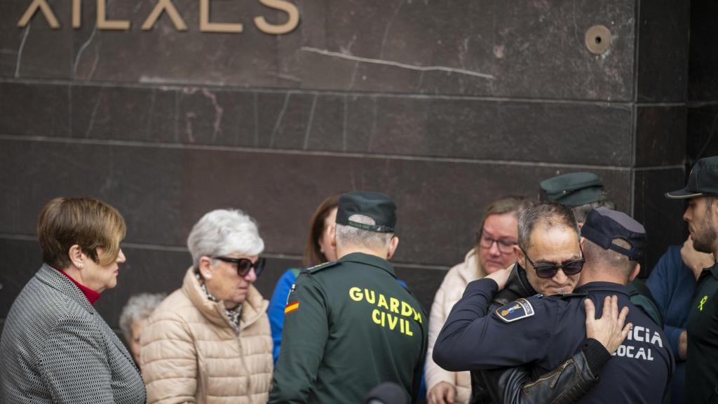 El hermano de la mujer asesinada junto a su hija de 12 años recibe consuelo al finalizar los cinco minutos de silencio guardados en Xilxes. Efe / Andreu Esteban