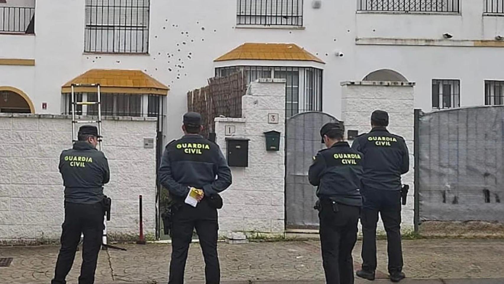 Un grupo de agentes de la Guardia Civil frente a la fachada de la casa de Gerena que ha sido tiroteada.