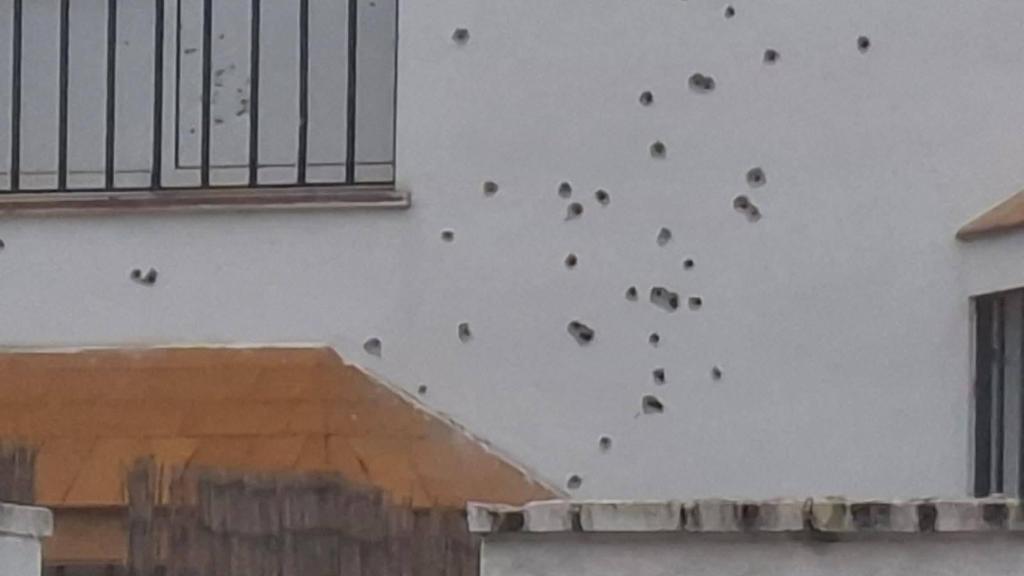 La fachada perforada por munición de guerra.