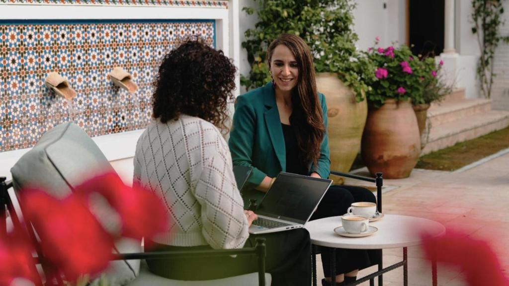 Claudia Gómez Estefan, CEO de Senniors y ClaraCare, y Noelia Hernández, de DISRUPTORES - EL ESPAÑOL, durante la entrevista en Puente Romano de Marbella (Málaga).