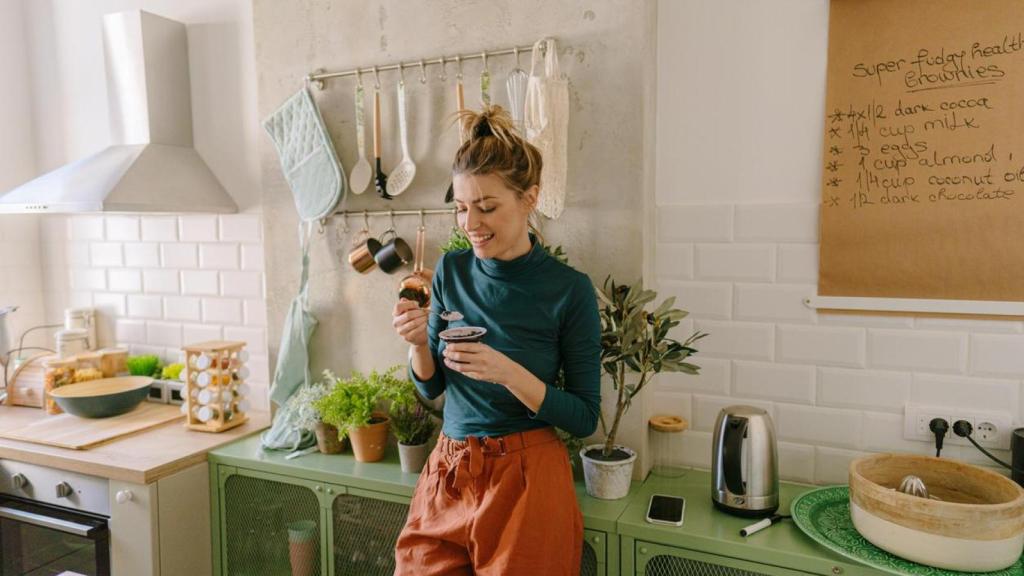 Una mujer disfruta de una merienda saludable en la cocina.