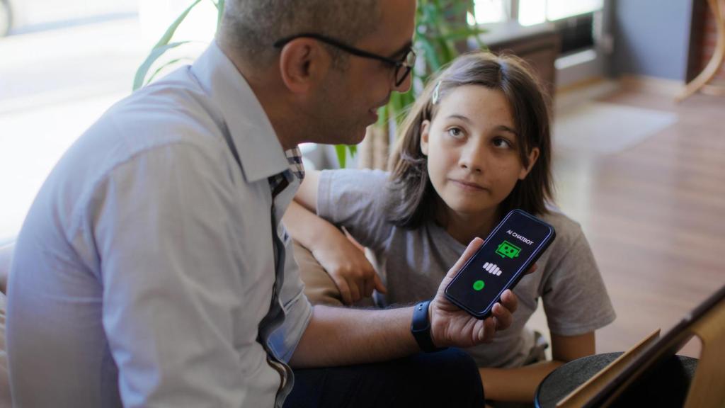 Padre e hija explorando un chatbot de IA.