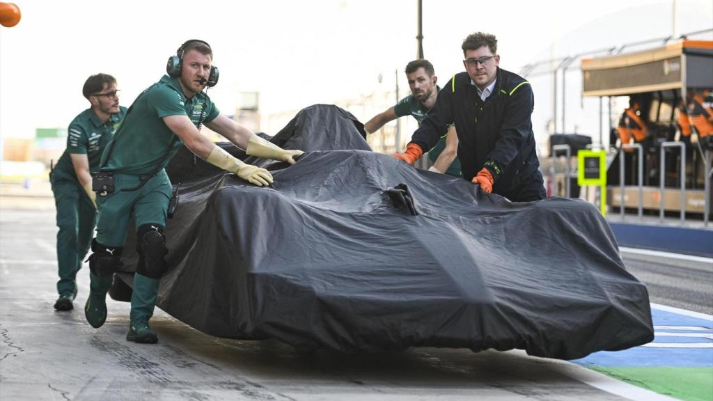 Los mecánicos de Aston Martin llevan el ARM26 de Fernando Alonso al garaje.