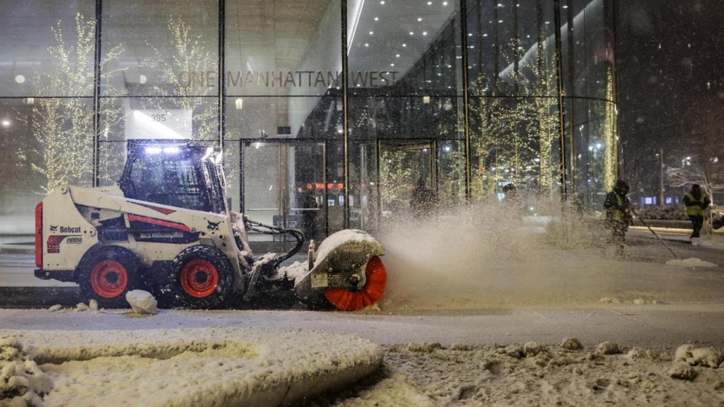 Un vehículo quitanieves limpia esta madrugada una calla de Nueva York.