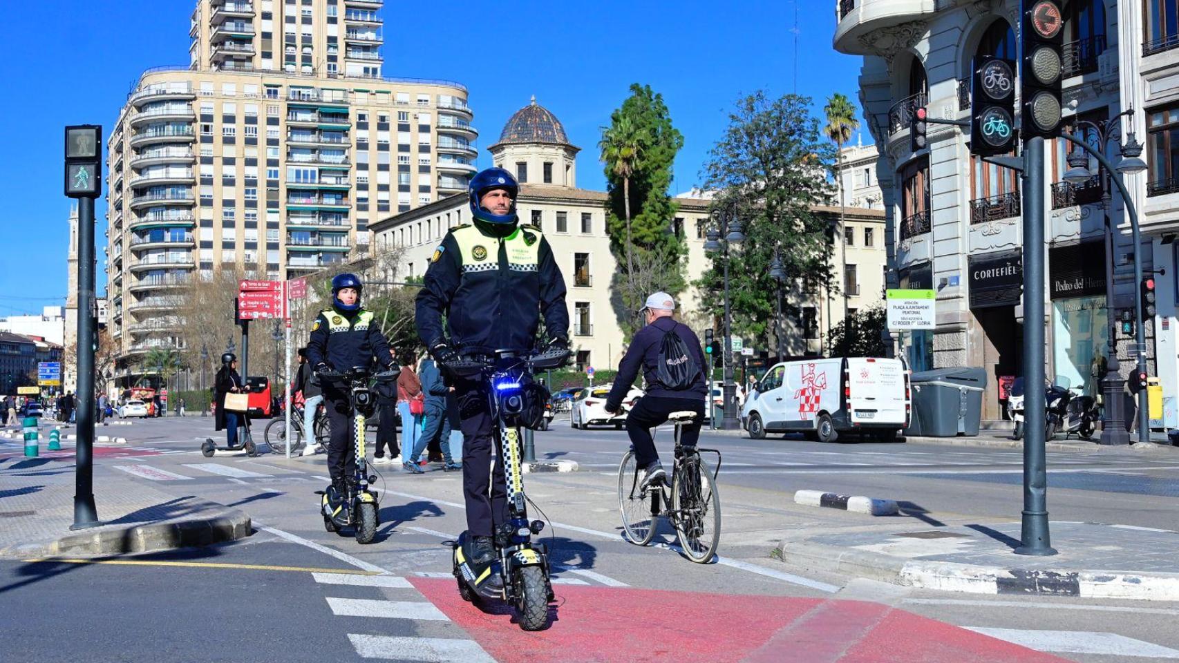 Agentes de la Policía Local de Valencia en patinete este lunes. EE