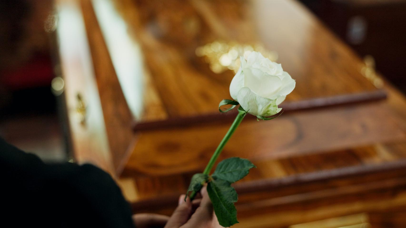 Una persona delante de un ataúd.