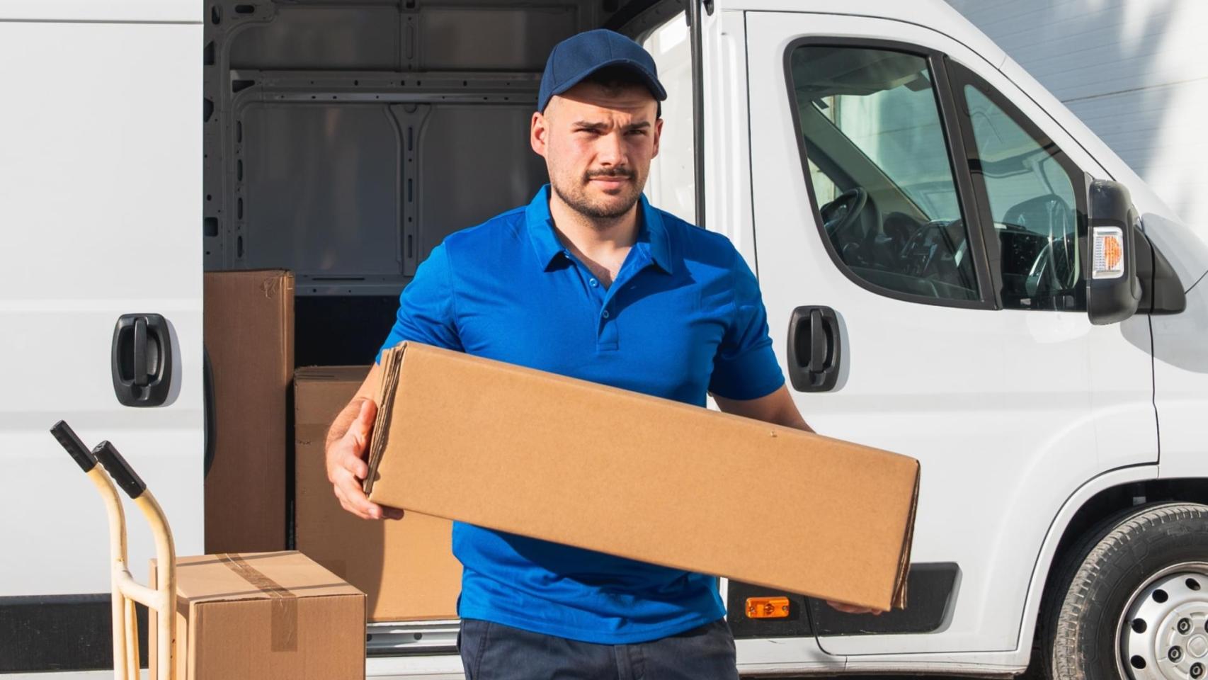 Un repartidor carga un paquete pesado