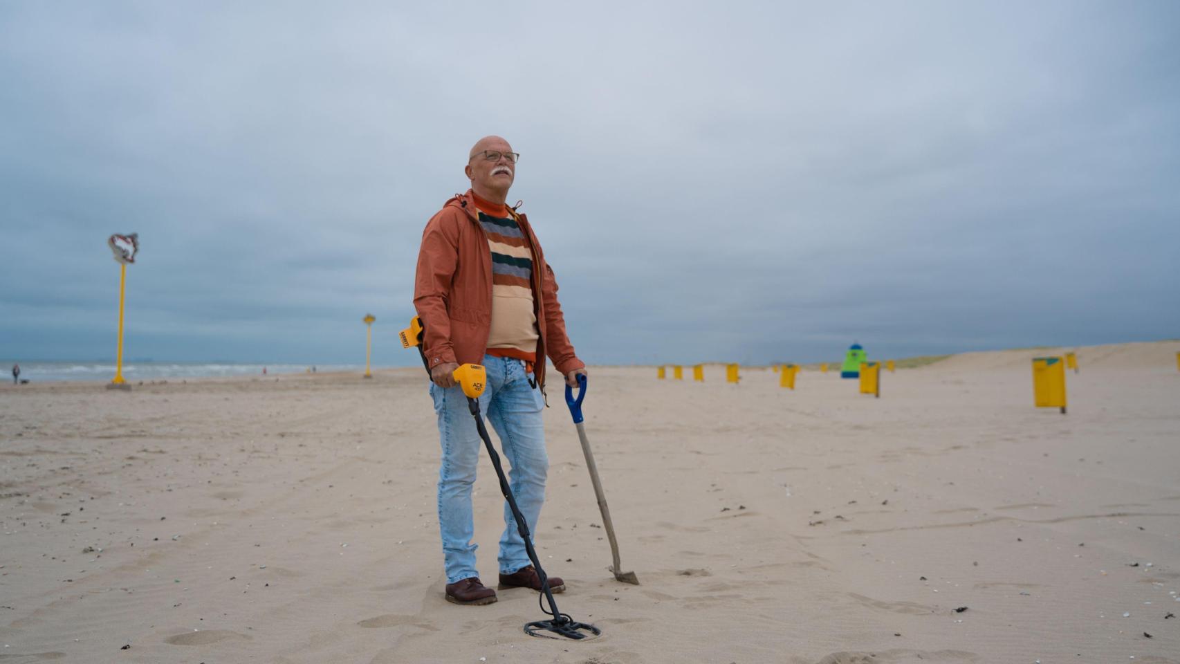 Un señor con un detector de metales buscando un tesoro en la playa