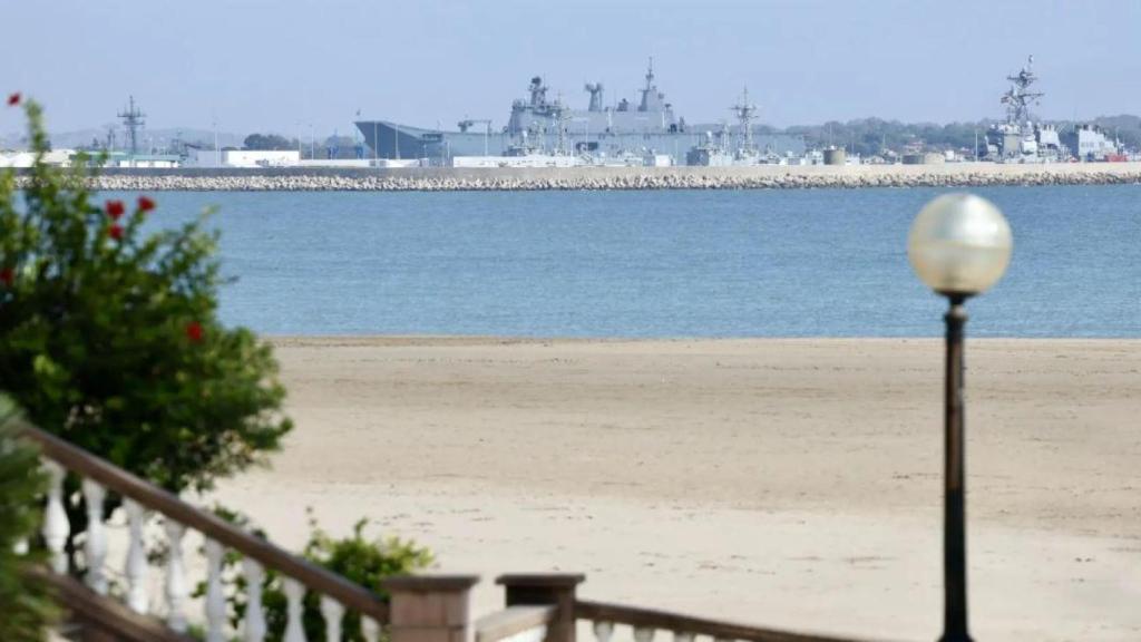 Un buque de guerra amarrado en el muelle de la base naval visto desde la playa de La Costilla de Rota.