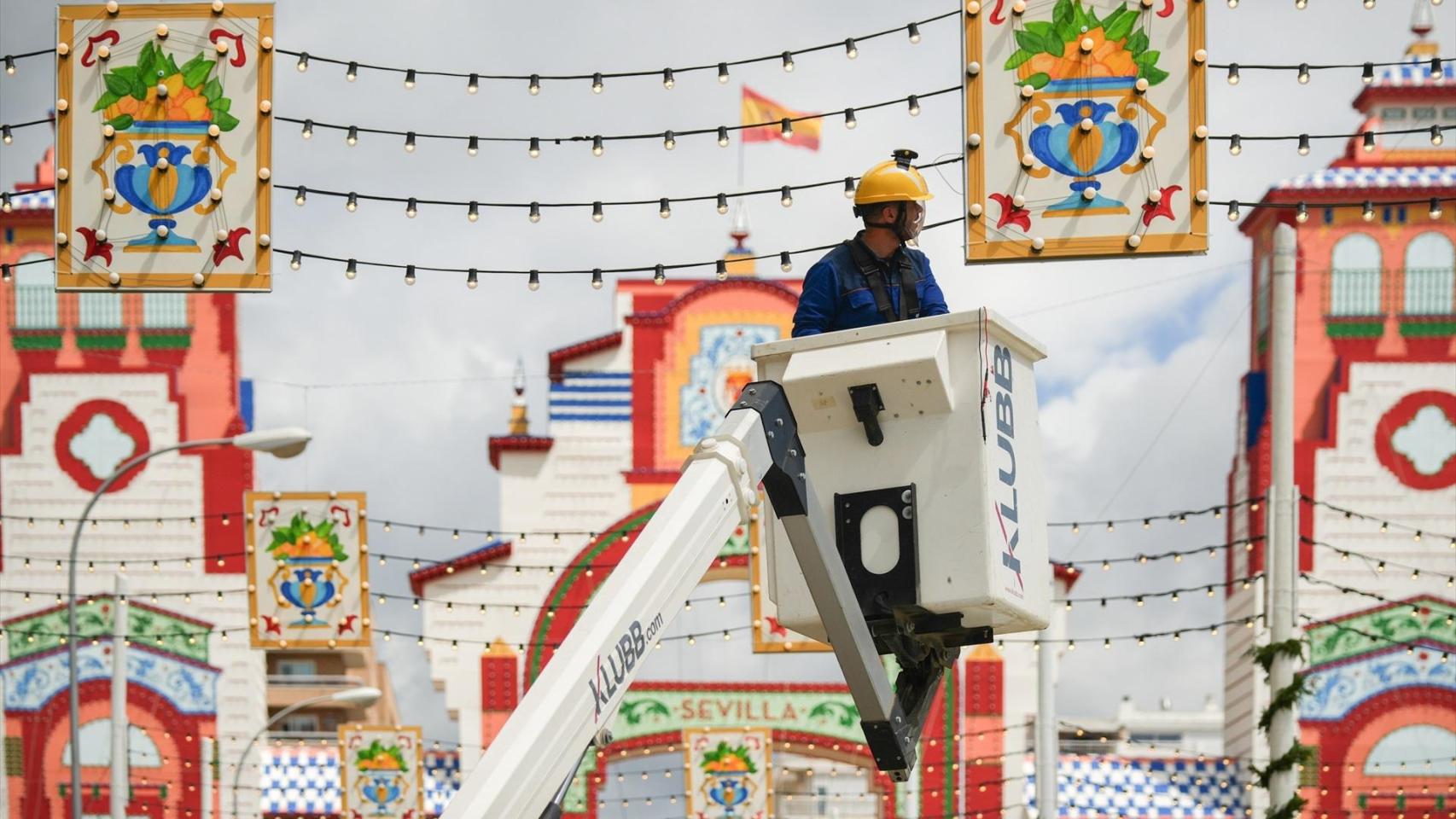 Un electricista comprobando el alumbrado en el Real de la Feria de Sevilla en 2025.